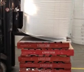 Conveyor forks loading goods onto pallets